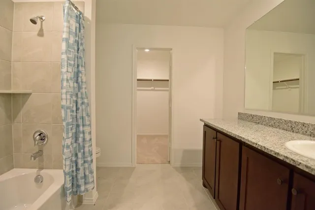 a bathroom with a granite countertop bathtub shower sink and mirror