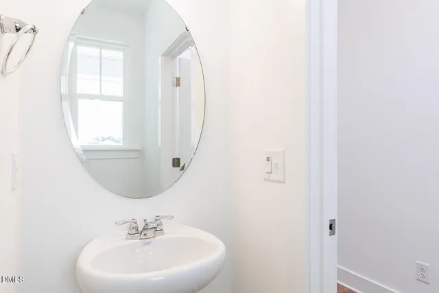 a kitchen with stainless steel appliances a sink a stove a refrigerator and white cabinets