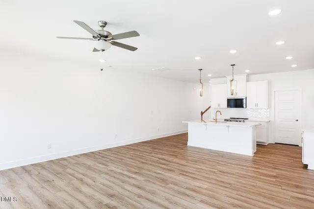 an empty room with window and ceiling fan