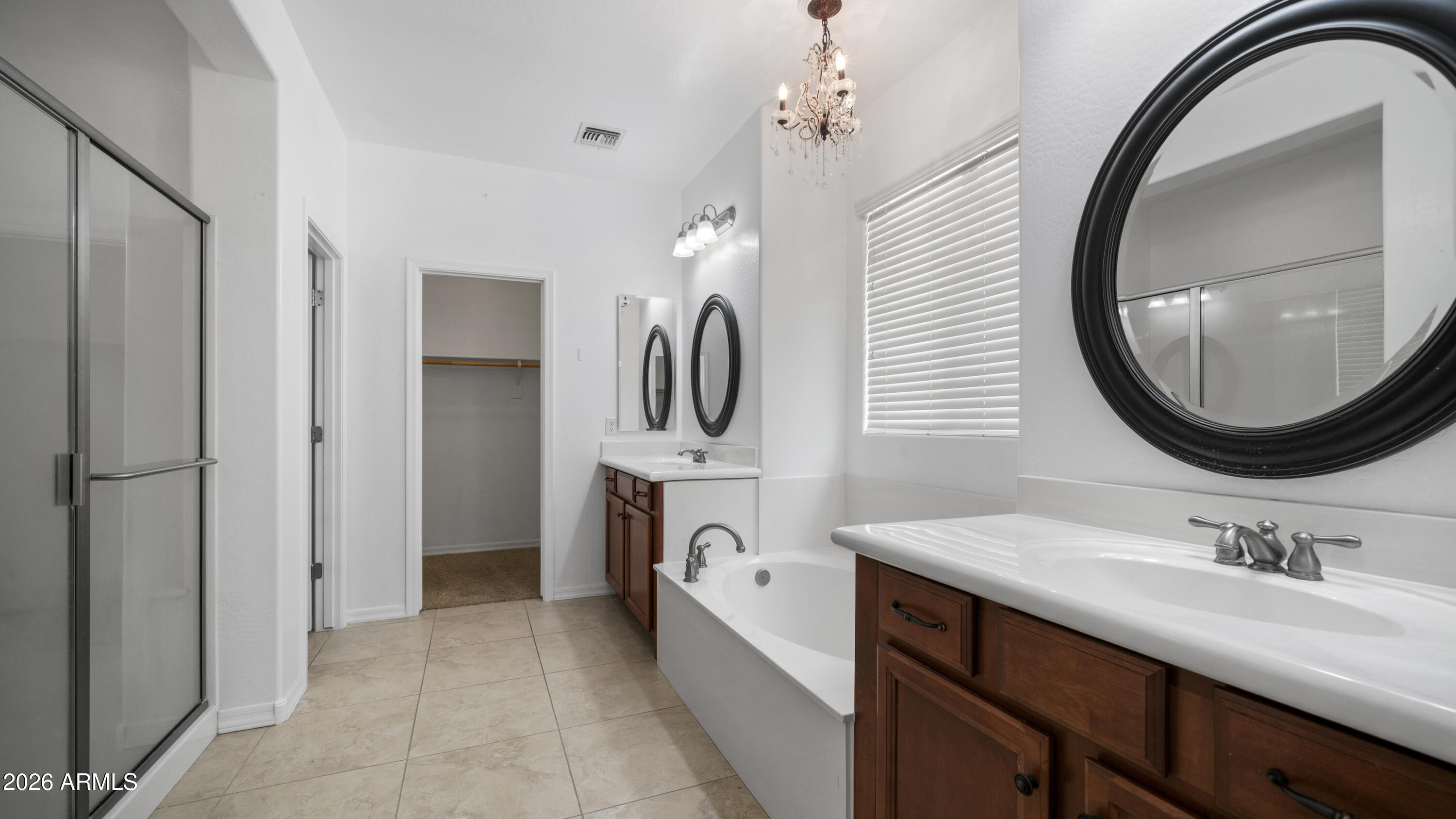 16159 West Granada Road Goodyear, AZ 85395 - Photo 24 of 41 a spacious bathroom with a sink a mirror a vanity and a shower
