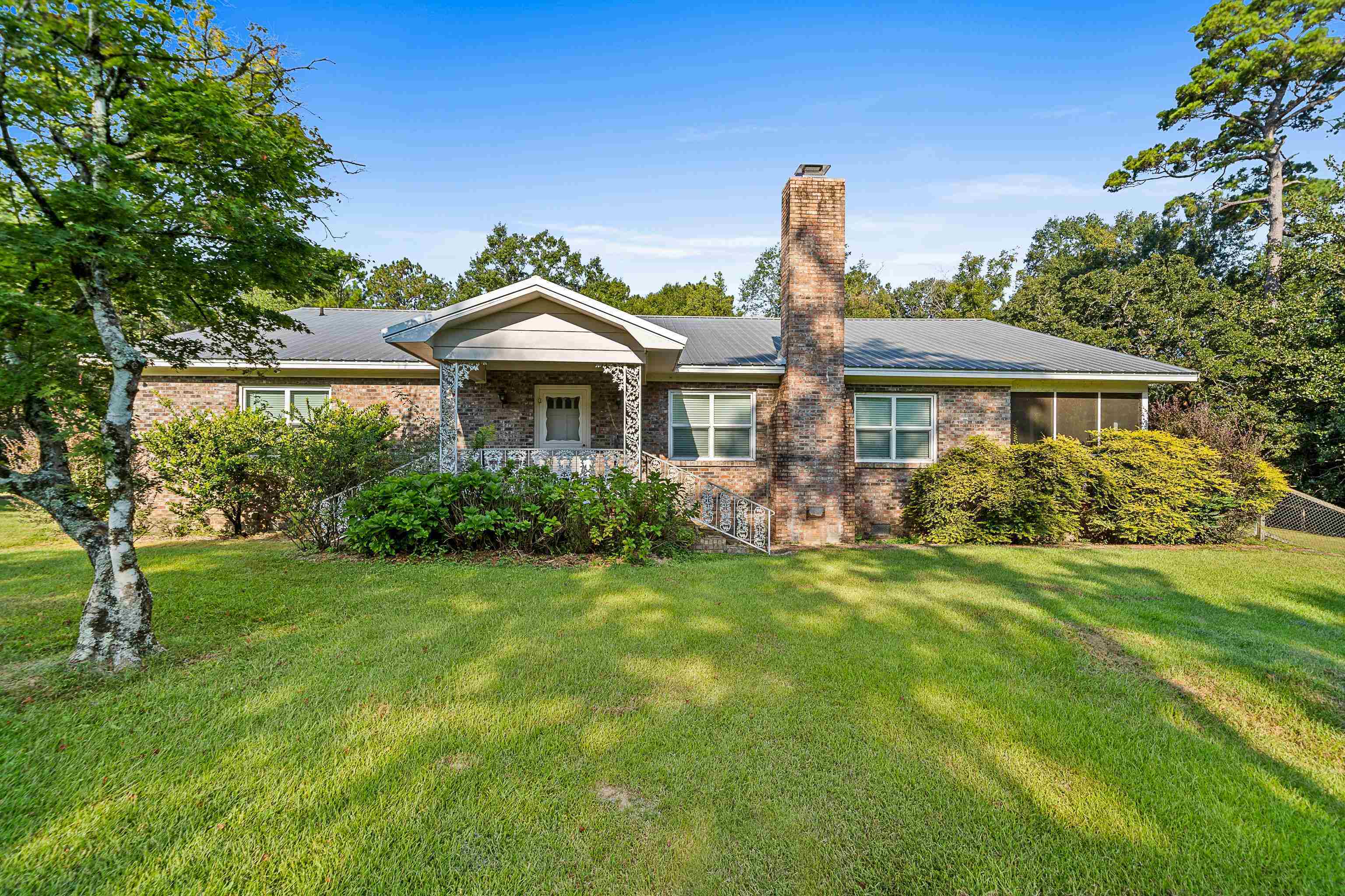 9350 Tompkins Road Stockton, AL 36579 - Photo 1 of 36 Single story home with brick siding, a front lawn, a chimney, and a metal roof
