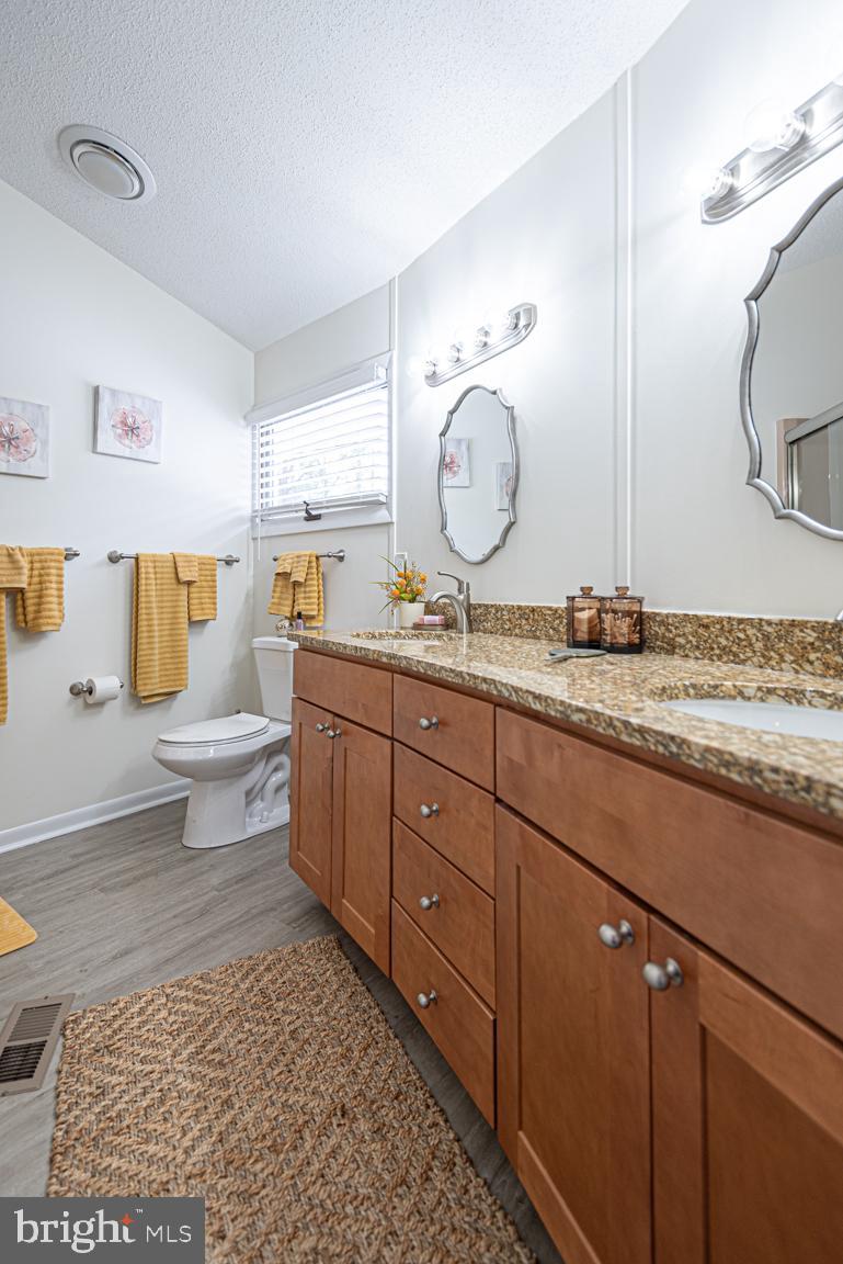 116 Watertown Road Ocean Pines, MD 21811 - Photo 43 of 78 a spacious bathroom with a granite countertop sink toilet and a mirror