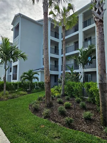 a view of a house with a yard and potted plants