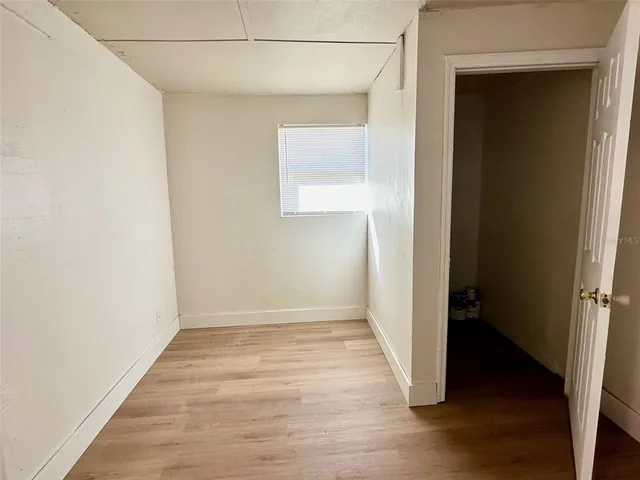 an empty room with wooden floor and closet