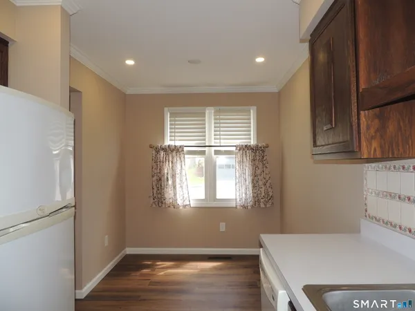 a view of a kitchen with wooden floor and a window