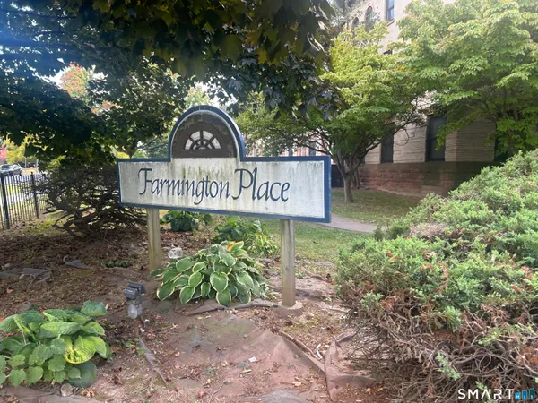 a view of a street sign under a large tree