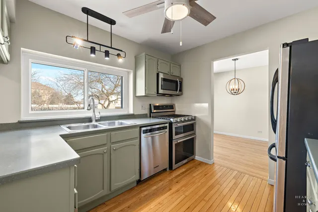 a kitchen with stainless steel appliances granite countertop a refrigerator a stove a sink and a microwave