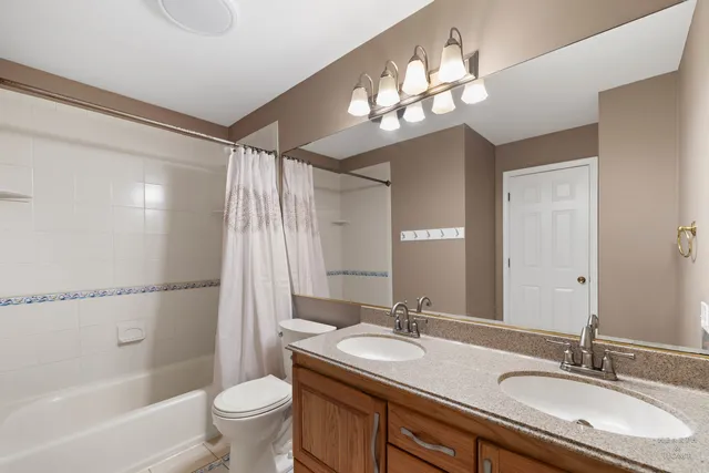 a bathroom with a granite countertop sink toilet a large mirror a shower and a bathtub