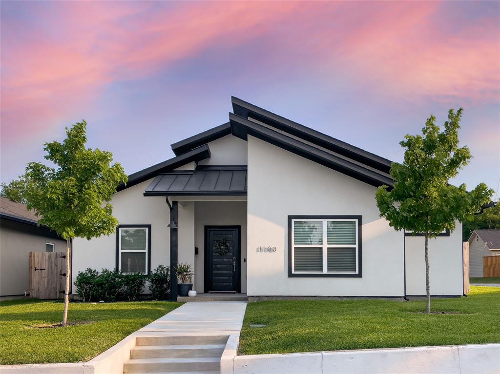 1108 Claude Street Dallas, TX 75203 - Photo 1 of 17 Contemporary exterior featuring a light-colored facade, black trim, and a prominent dark metal roof