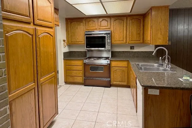 a kitchen with stainless steel appliances granite countertop a stove a sink and a microwave