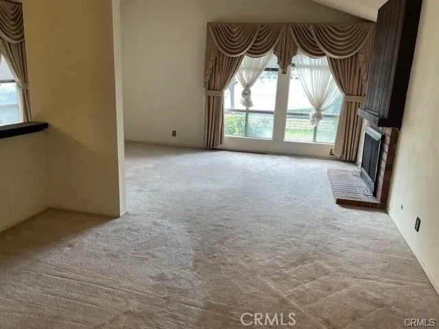 an empty room with a fireplace and windows