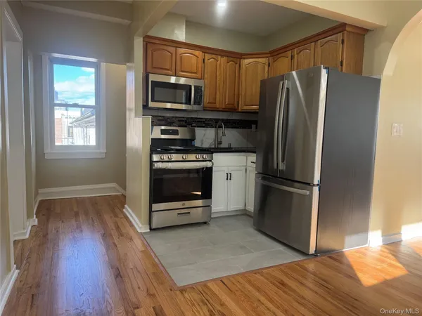 a kitchen with granite countertop a refrigerator and a stove top oven