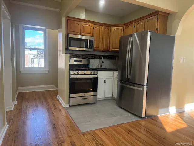 a kitchen with granite countertop a refrigerator and a stove top oven