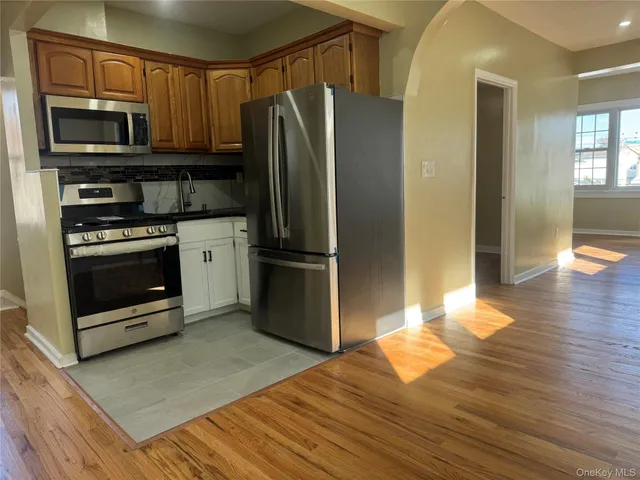 a kitchen with granite countertop a refrigerator stove and microwave