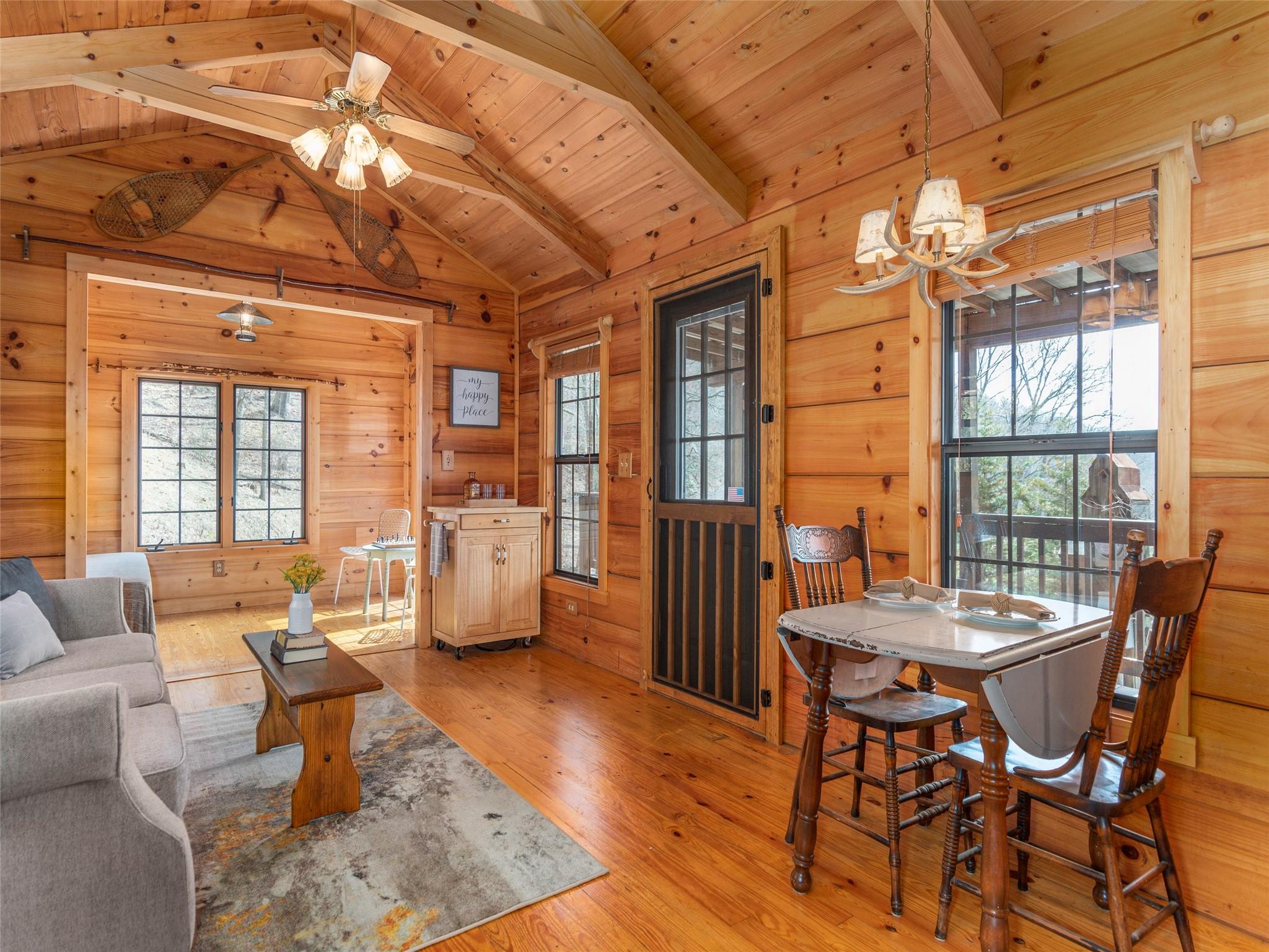 239 Sugar Hill Road Clyde, NC 28721 - Photo 7 of 20 a dining room with furniture a chandelier and wooden floor