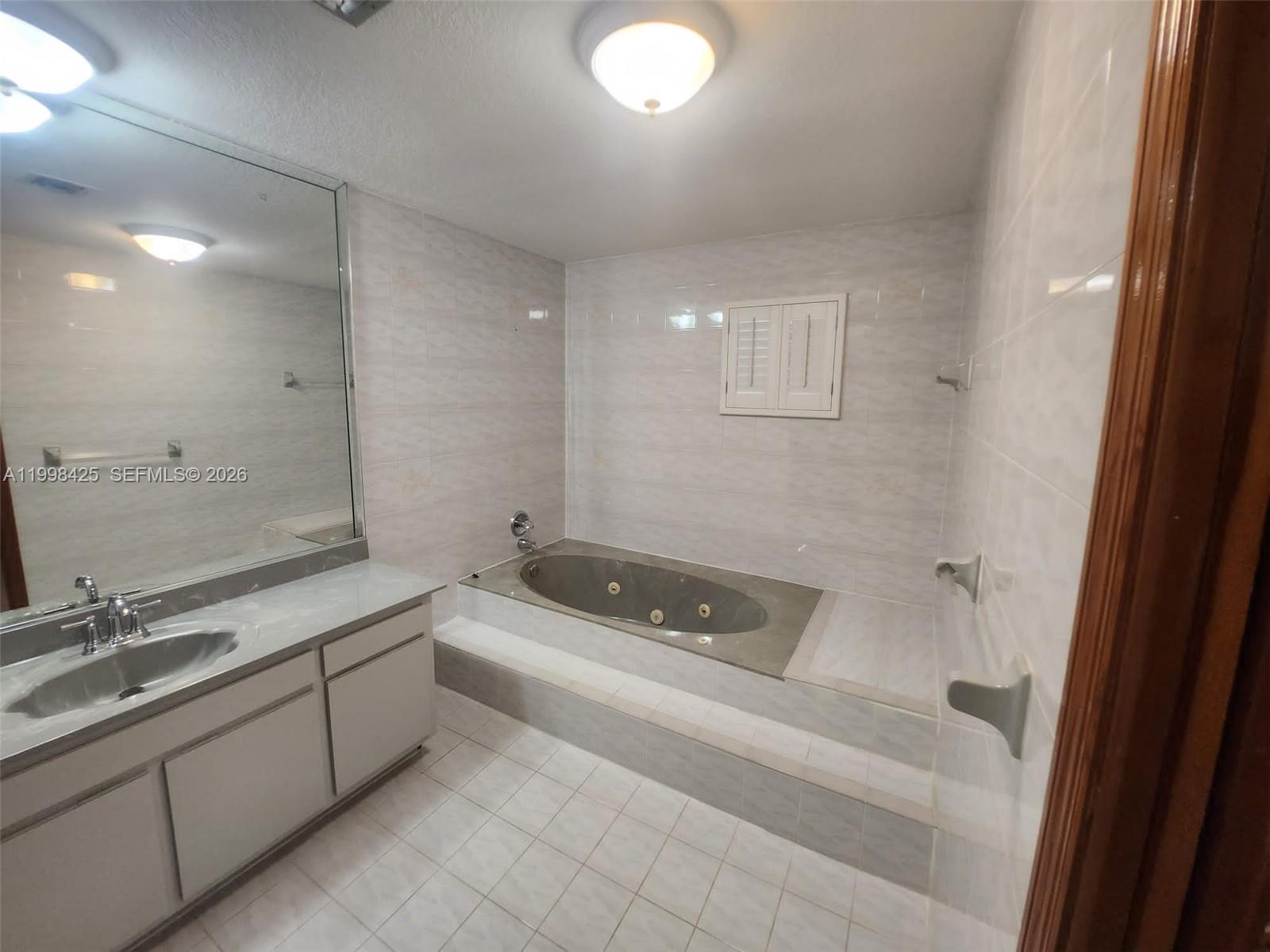 2980 Southwest 111th Avenue Miami, FL 33165 - Photo 18 of 39 a bathroom with a tub a sink and mirrors