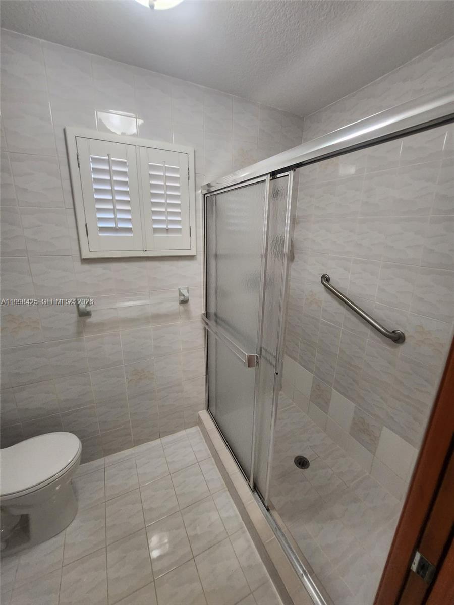2980 Southwest 111th Avenue Miami, FL 33165 - Photo 19 of 39 a bathroom with a shower a toilet and a sink