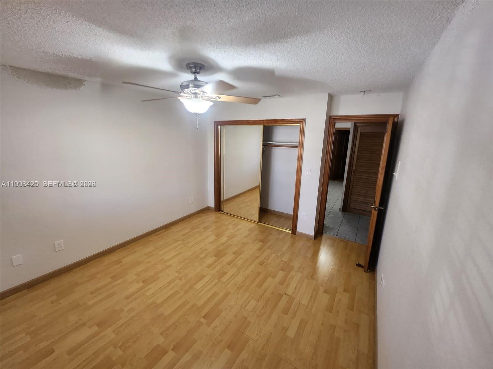 2980 Southwest 111th Avenue Miami, FL 33165 - Photo 27 of 39 an empty room with wooden floor and ceiling fan