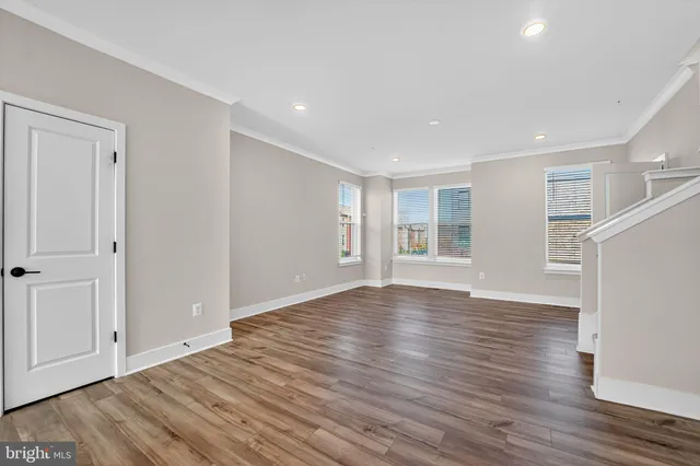 a view of empty room with wooden floor and window