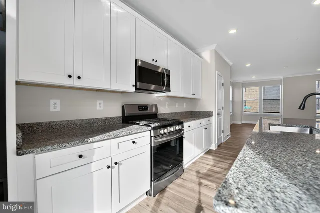 a large kitchen with stainless steel appliances granite countertop a stove a sink and a granite counter tops
