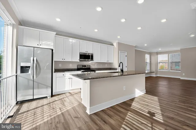 a kitchen with stainless steel appliances a refrigerator sink and microwave
