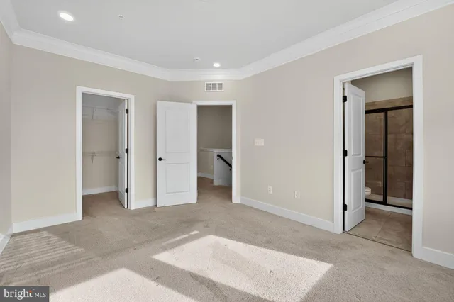 an empty room with closet and a bathroom