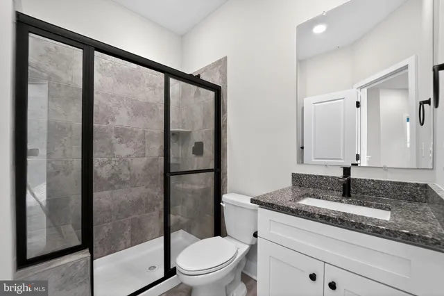 a bathroom with a granite countertop sink toilet and shower