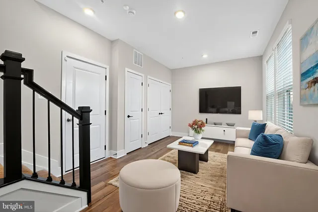 a living room with furniture a flat screen tv and a view of bathroom