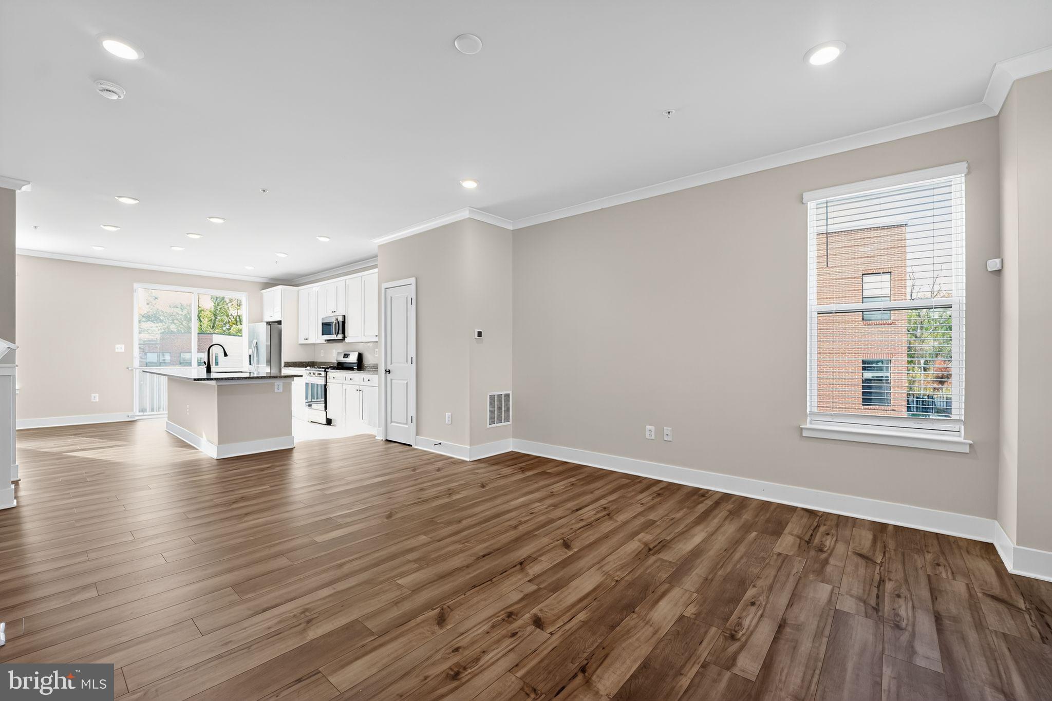 1511 Roland Heights Avenue Baltimore, MD 21211 - Photo 7 of 42 a view of an empty room with wooden floor and a window