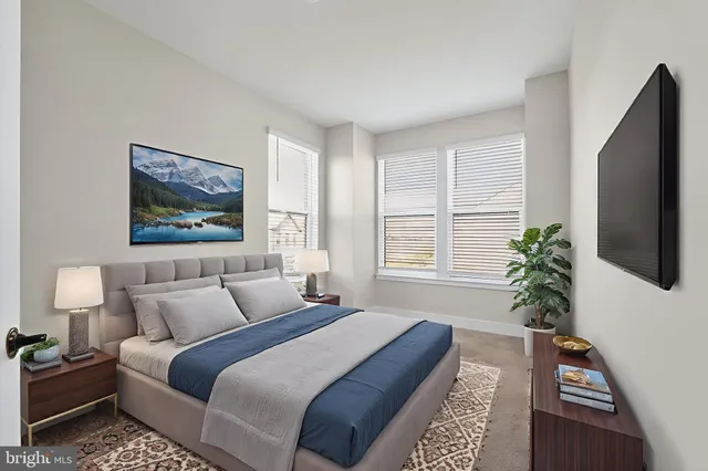 a bedroom with bed painting on the wall and a potted plant