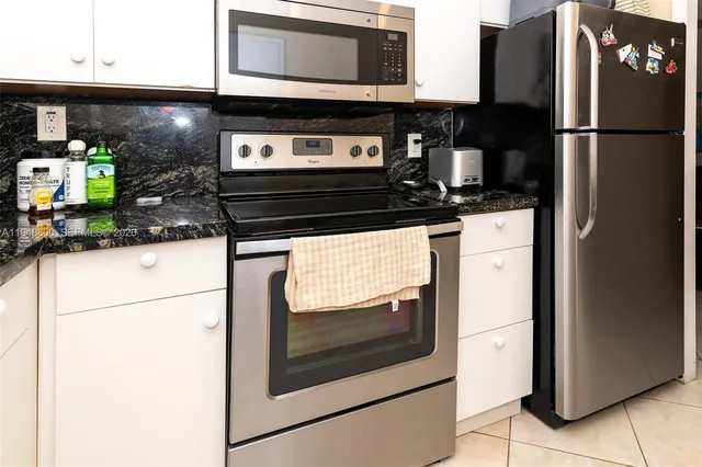 a kitchen with stainless steel appliances granite countertop a refrigerator and a stove