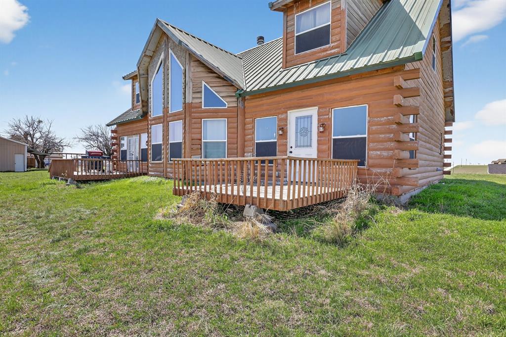 131 Hawk Ridge Decatur, TX 76234 - Photo 9 of 34 Rear view of house with a deck, a lawn, a metal roof, and log siding