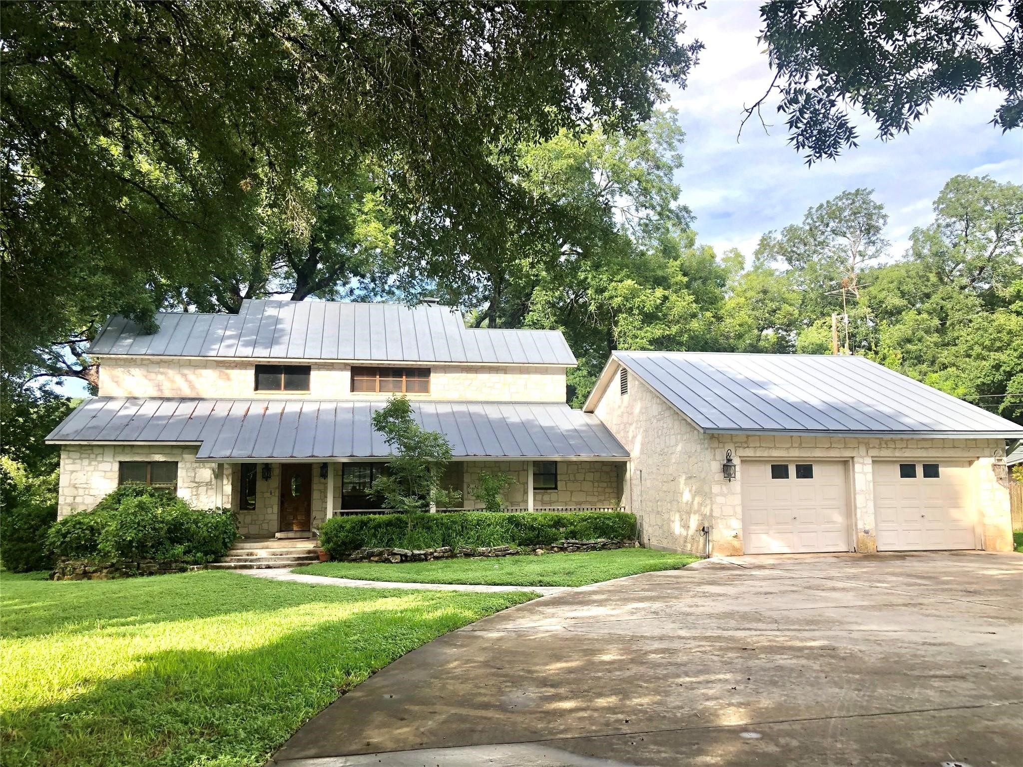9030 River Road New Braunfels, TX 78132 - Photo 2 of 25 a front view of a house with a yard table and chairs