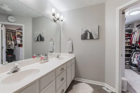 a bathroom with a double vanity sink a mirror and shower