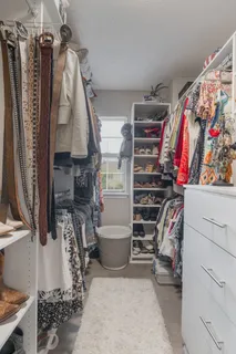 a view of walk in closet with clothes and shoes