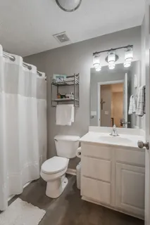 a bathroom with a sink a toilet and shower