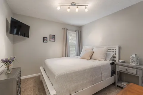 a bedroom with a large bed and a flat screen tv