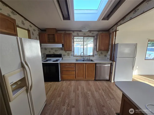 a kitchen with stainless steel appliances a refrigerator and wooden cabinets