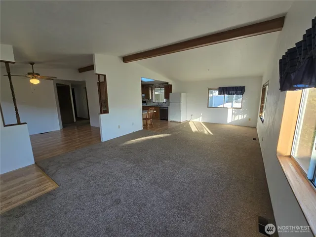 a view of a livingroom with an empty space and a window