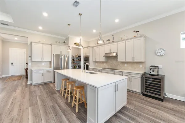 a large kitchen with kitchen island a sink a counter space and stainless steel appliances