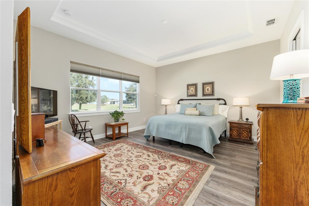 8843 Southwest 57th Pl Road Ocala, FL 34481 - Photo 27 of 64 a bedroom with a large bed a large window with table and chair