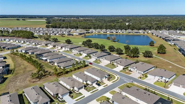 an aerial view of residential houses with outdoor space and ocean view