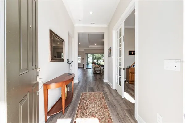 a view of a hallway with wooden floor and staircase
