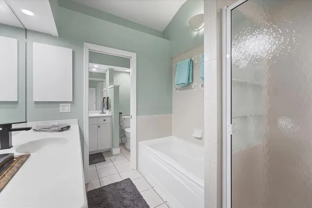 a bathroom with a tub sink and a mirror