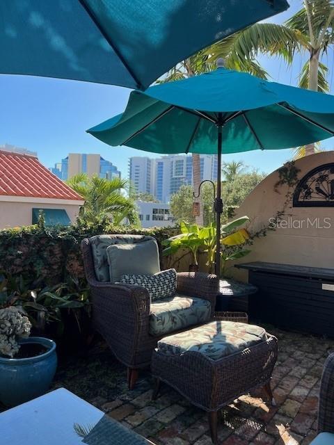 200 Cocoanut Avenue, Unit 7 Sarasota, FL 34236 - Photo 29 of 32 a patio with tables and chairs under an umbrella