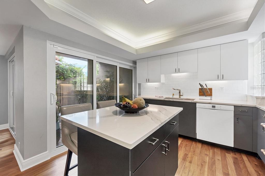200 Cocoanut Avenue, Unit 7 Sarasota, FL 34236 - Photo 3 of 32 a kitchen with sink cabinets and wooden floor