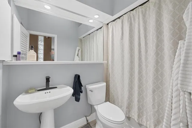 a bathroom with a sink a toilet and shower curtain