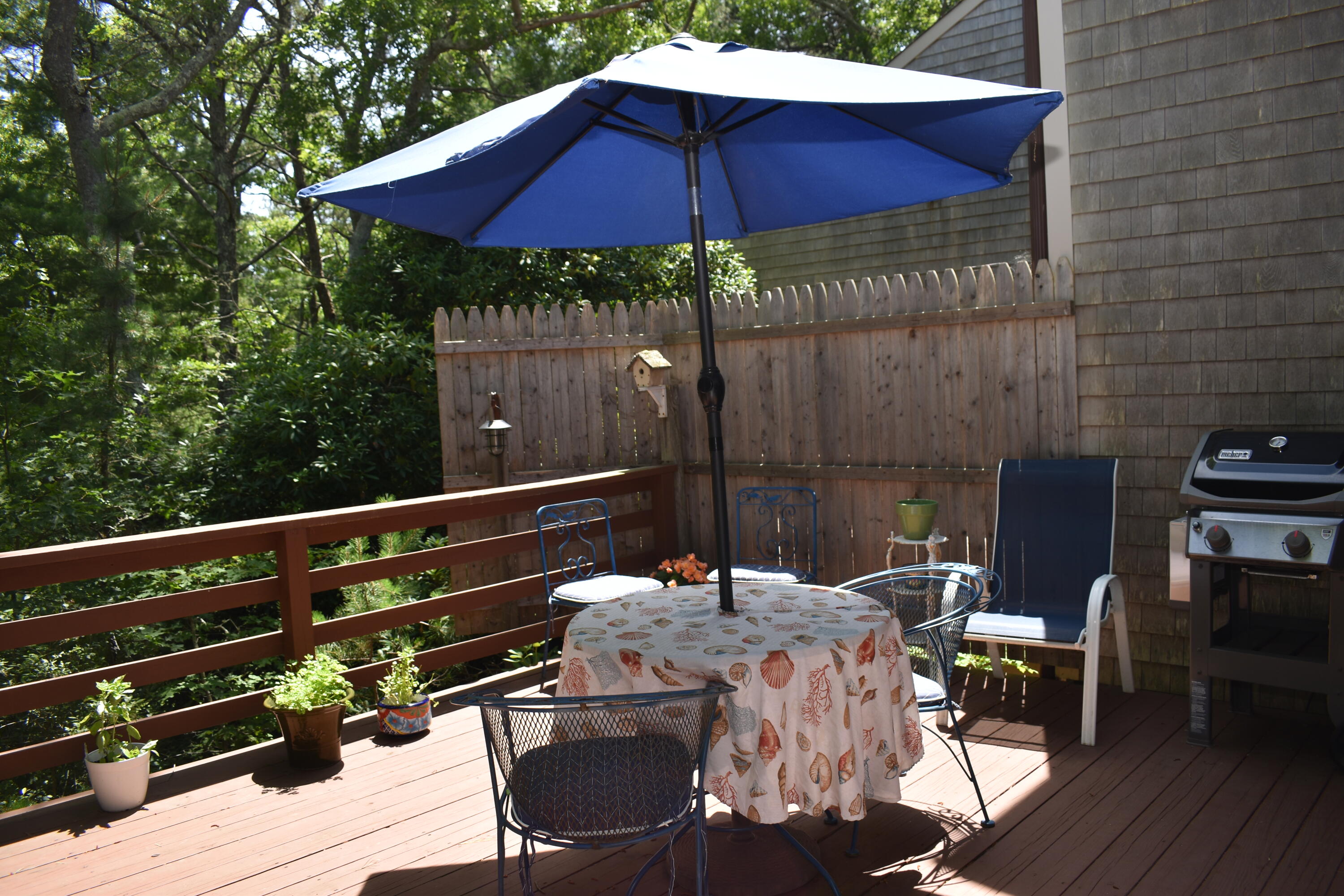 6 Round House Road Bourne, MA 02532 - Photo 19 of 25 a patio with wooden floor a yard a table and chairs