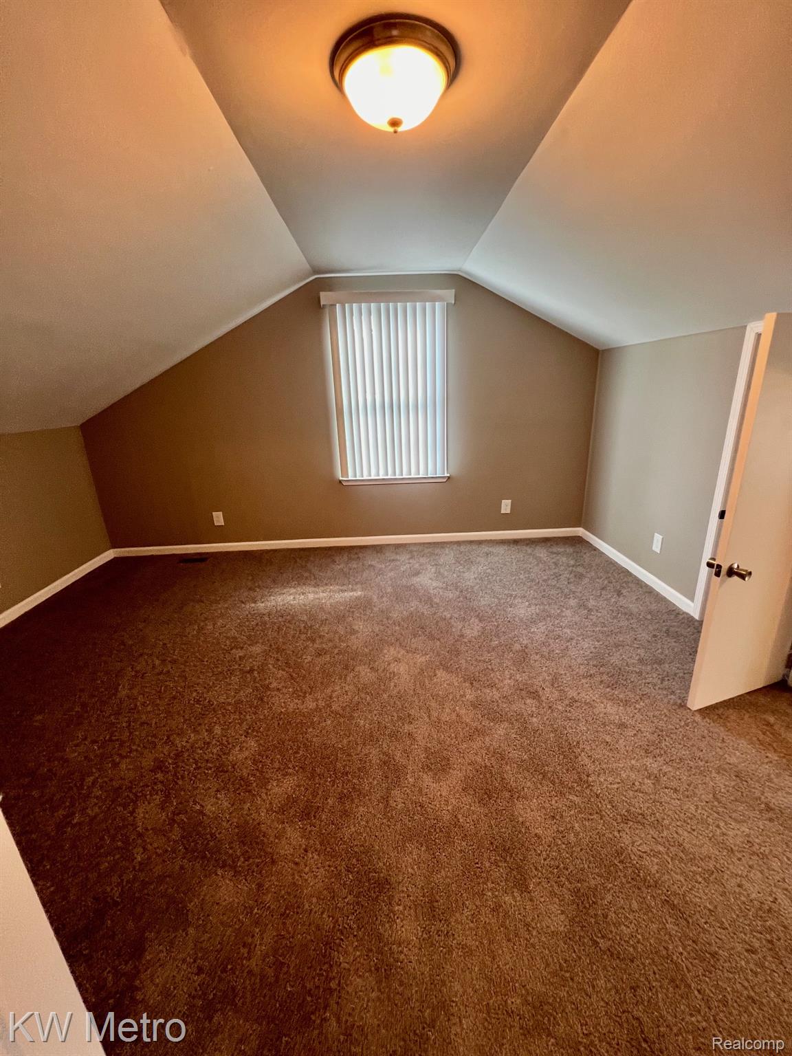 939 Webb Street Detroit, MI 48202 - Photo 16 of 19 Carpeted room featuring sloped ceilings, a single window with blinds, and a flush-mount ceiling light fixture