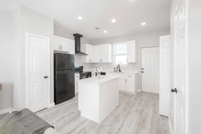 a kitchen with a refrigerator and a sink